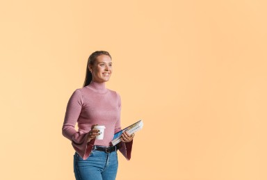 Vrouw lacht met boek en koffie in haar hand